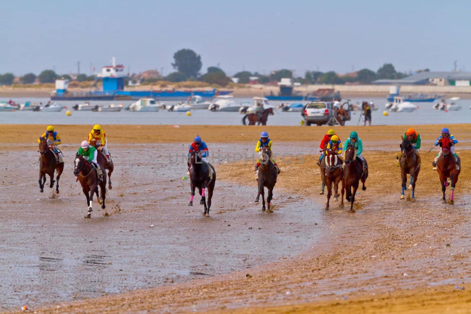 SANLUCAR DE BARRAMEDA, CADIZ, SPAIN - AUGUST 11: Unidentified riders race horses on Sanlucar de Barrameda beach on August 11, 2011 in Sanlucar de Barrameda, Cadiz, Spain.
