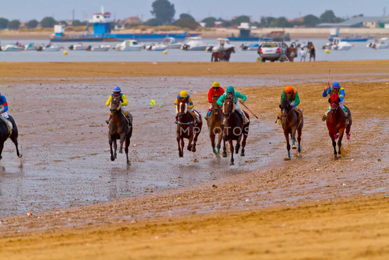 SANLUCAR DE BARRAMEDA, CADIZ, SPAIN - AUGUST 11: Unidentified riders race horses on Sanlucar de Barrameda beach on August 11, 2011 in Sanlucar de Barrameda, Cadiz, Spain.