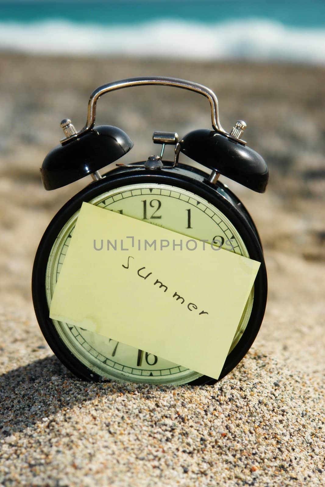 close-up of a clock with a note at a beach