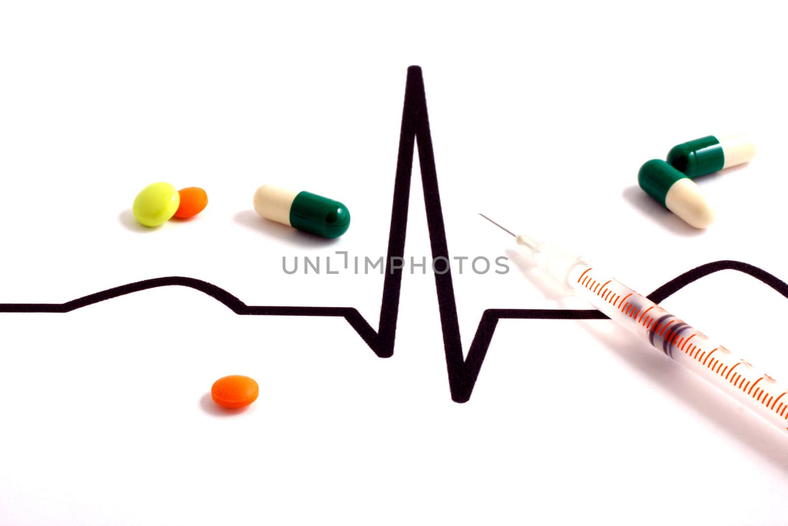 Pills lying on ECG diagram - white background