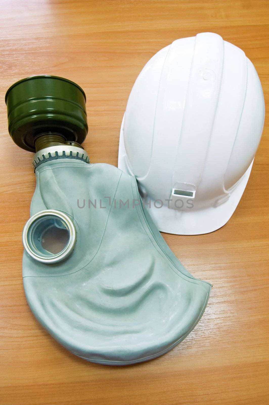 The white helmet and gas mask on the background of a wooden tabletop