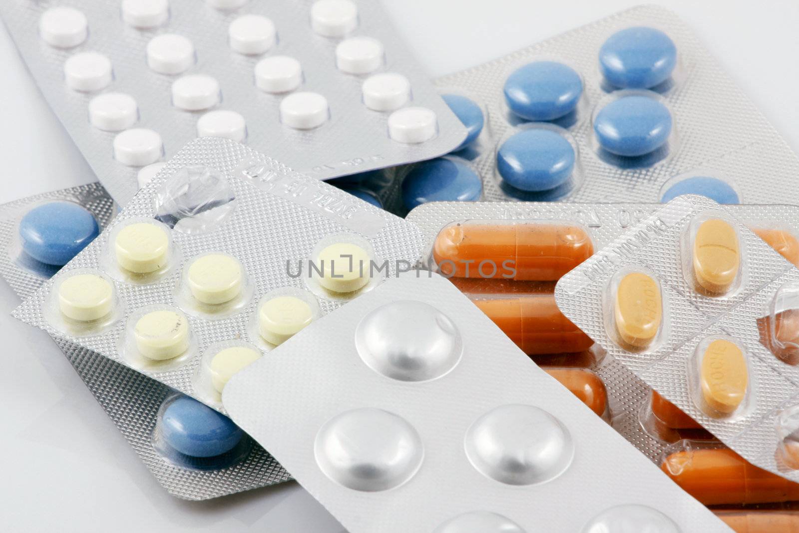 Pills of many shapes and colors grouped together