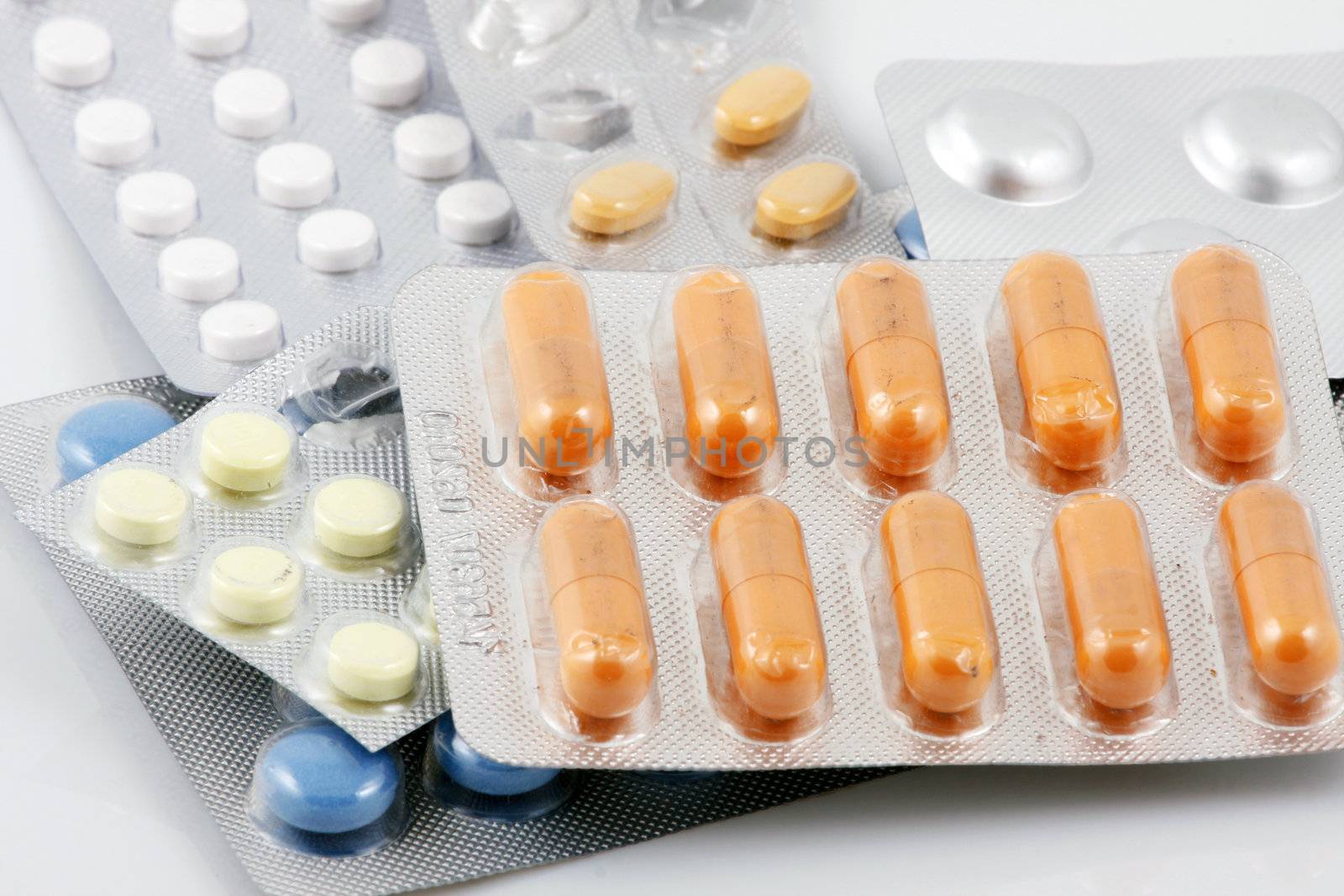 Pills of many shapes and colors grouped together