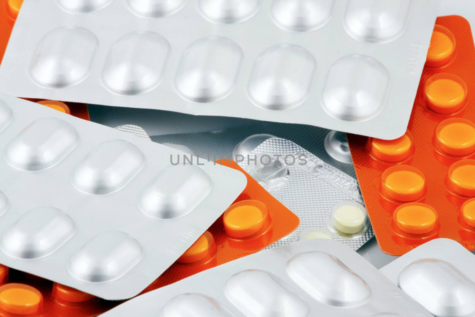 Pills of many shapes and colors grouped together