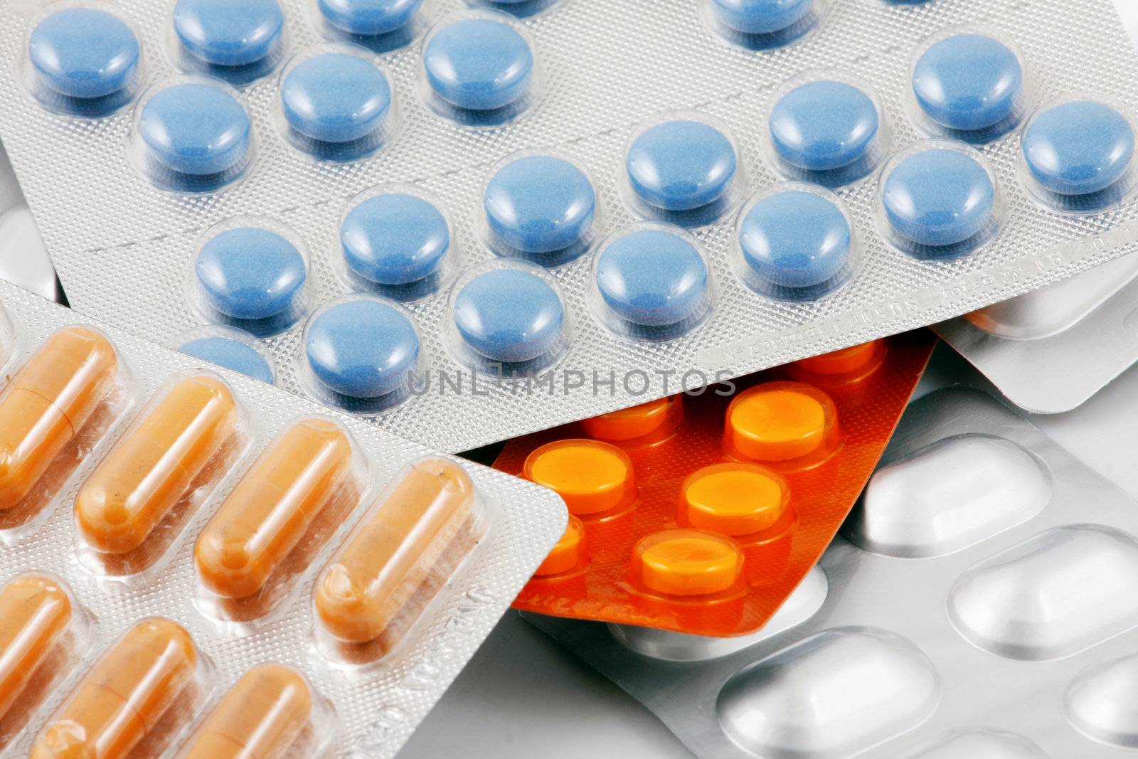 Pills of many shapes and colors grouped together