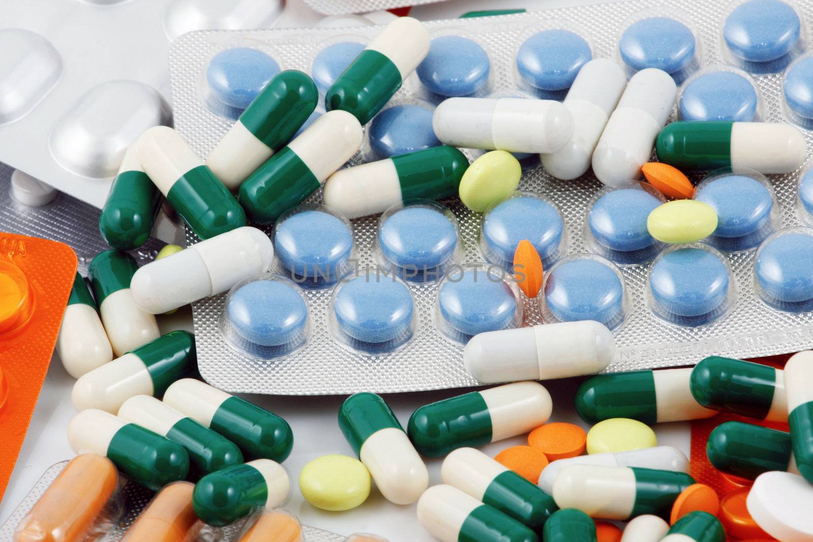 Pills of many shapes and colors grouped together