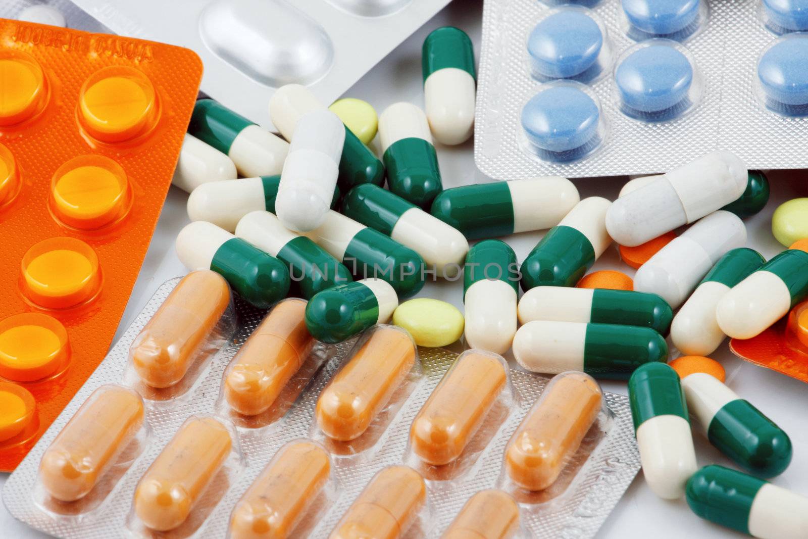 Pills of many shapes and colors grouped together