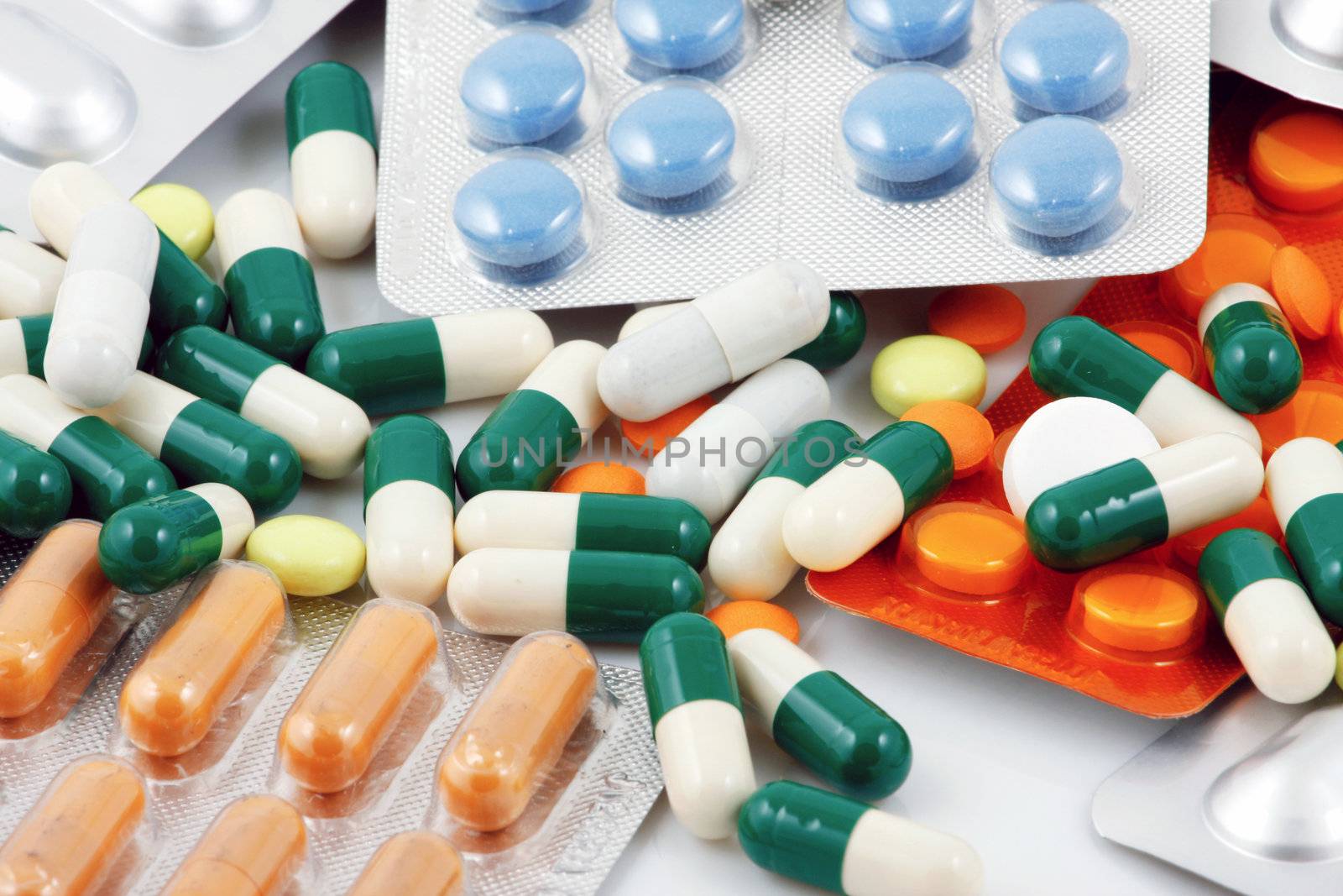 Pills of many shapes and colors grouped together