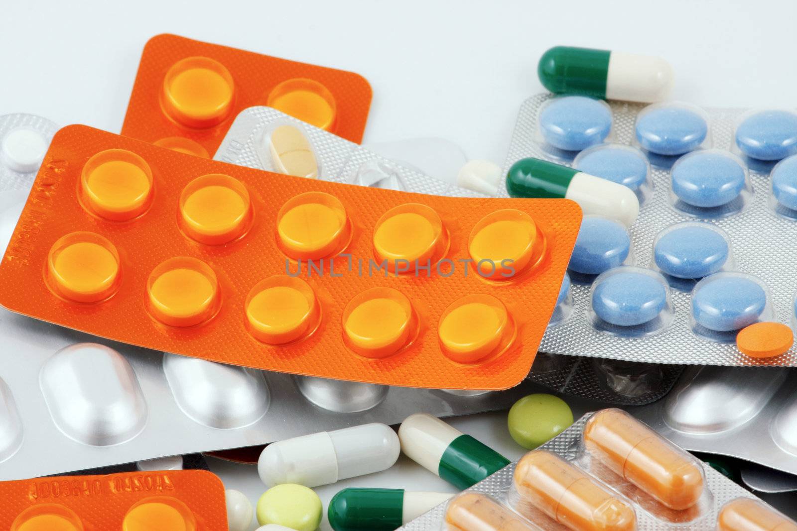 Pills of many shapes and colors grouped together