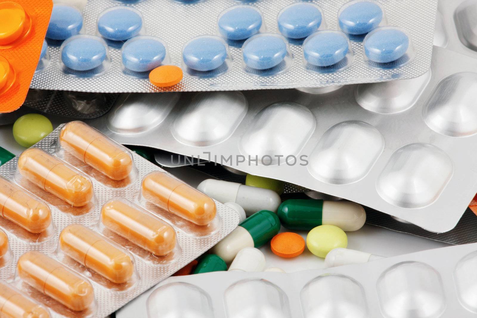 Pills of many shapes and colors grouped together