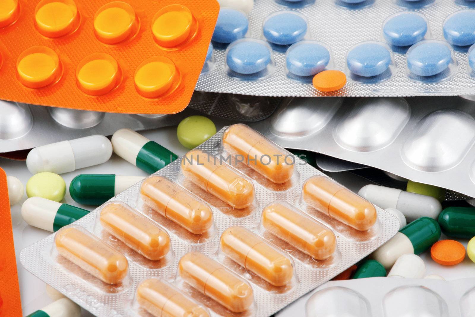 Pills of many shapes and colors grouped together
