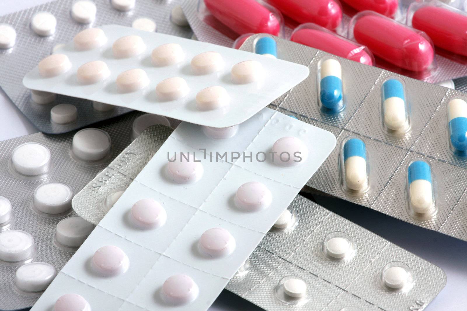 Pills of many shapes and colors grouped together