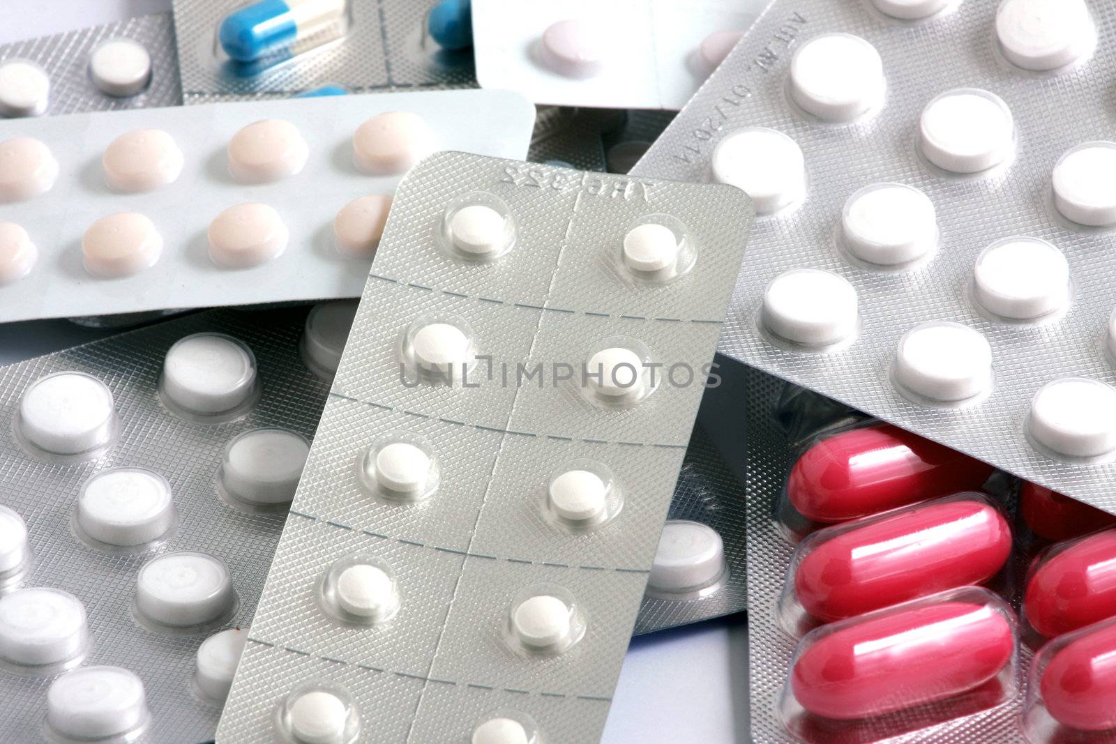 Pills of many shapes and colors grouped together