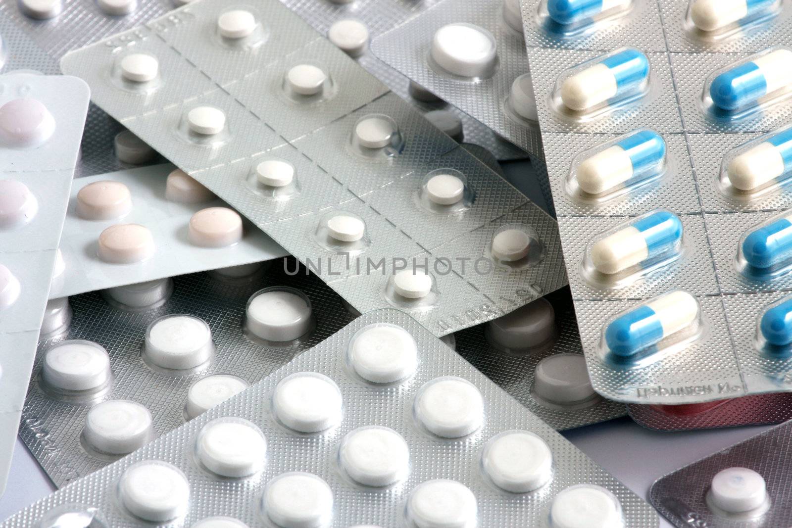 Pills of many shapes and colors grouped together