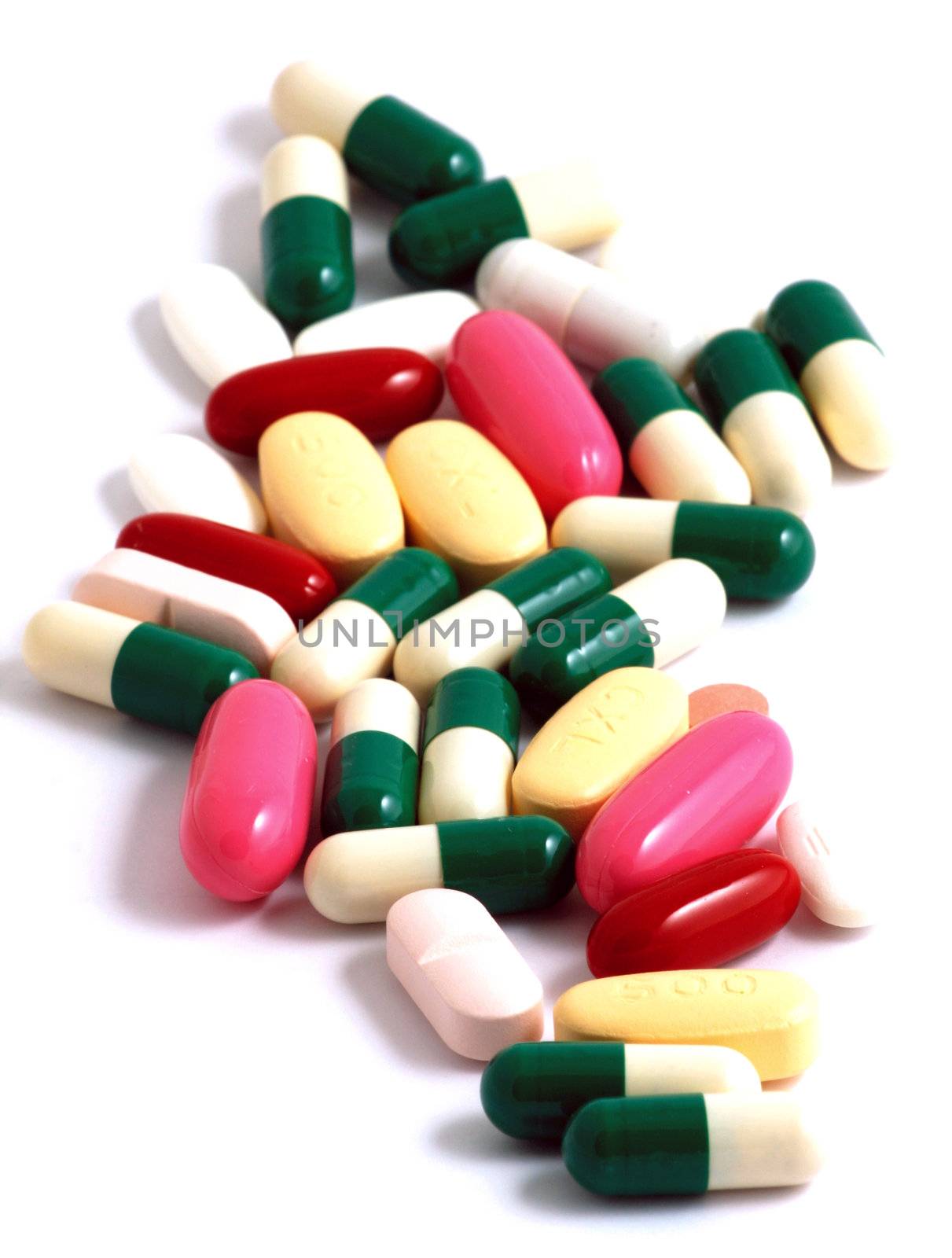 Pills of many shapes and colors grouped together