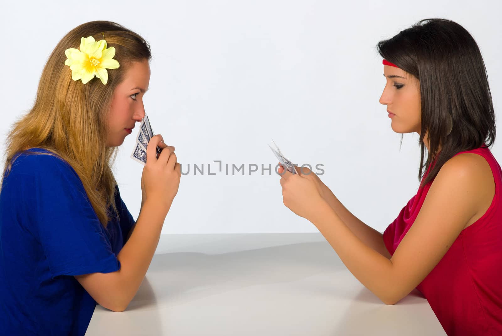 Blond and brunette in  a serious poker confrontation