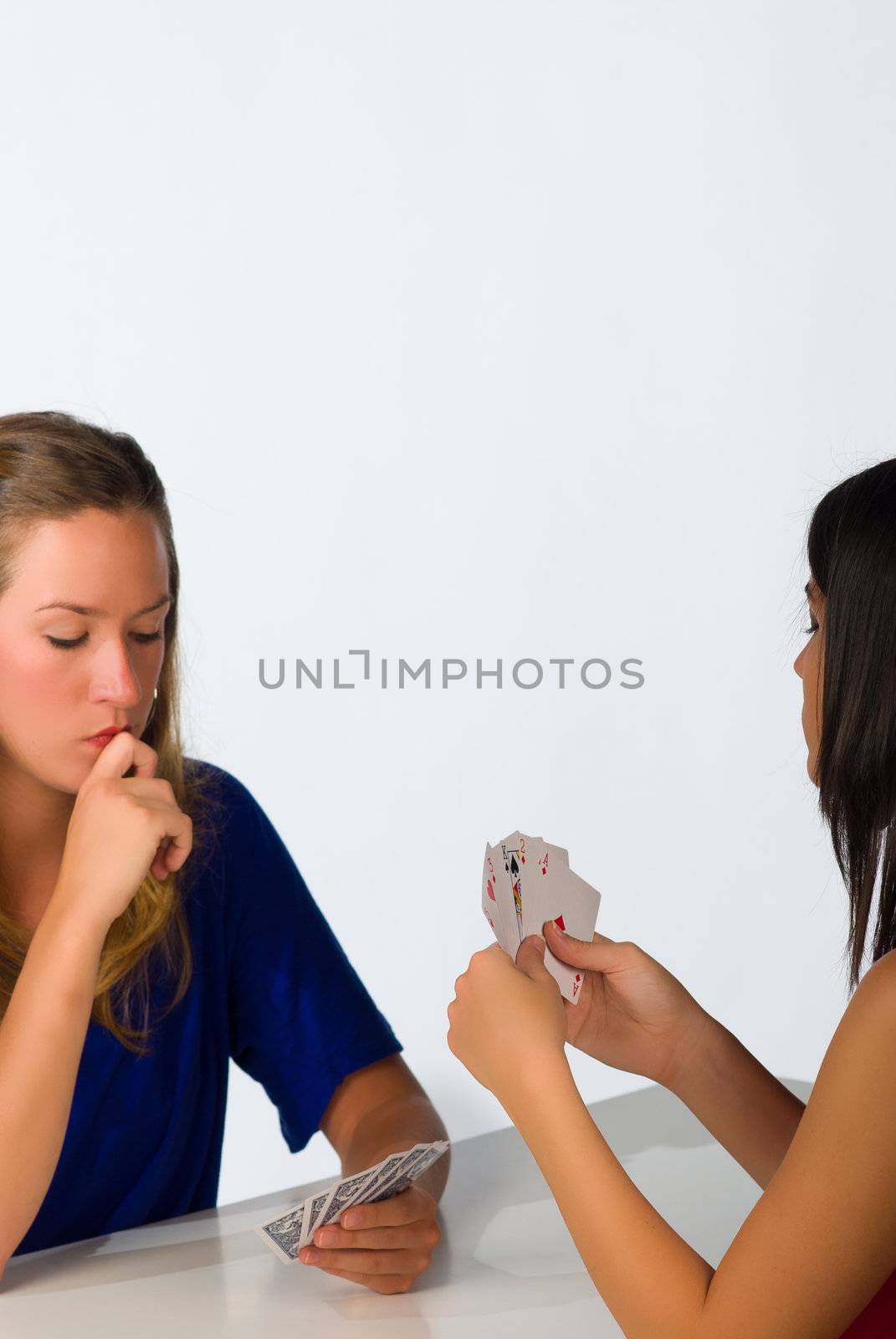 Blond and brunette in  a serious poker confrontation