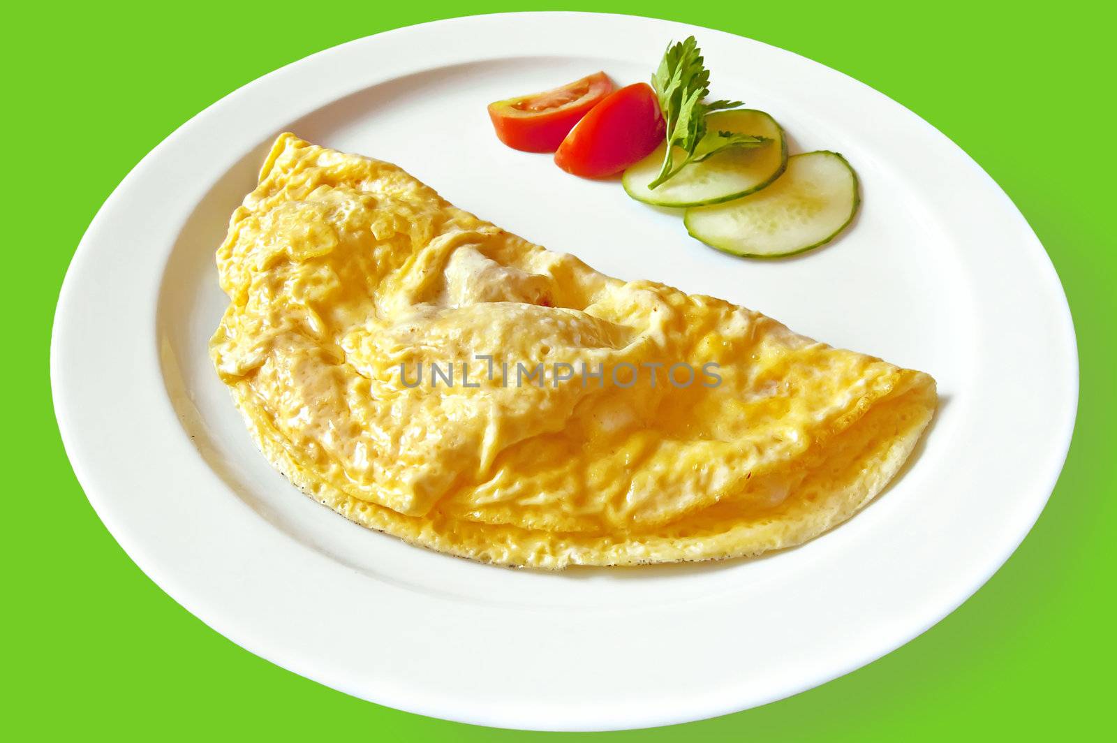 Yellow omelet, two slices of red tomatoes and cucumber, a sprig of parsley on the dish isolated on green background