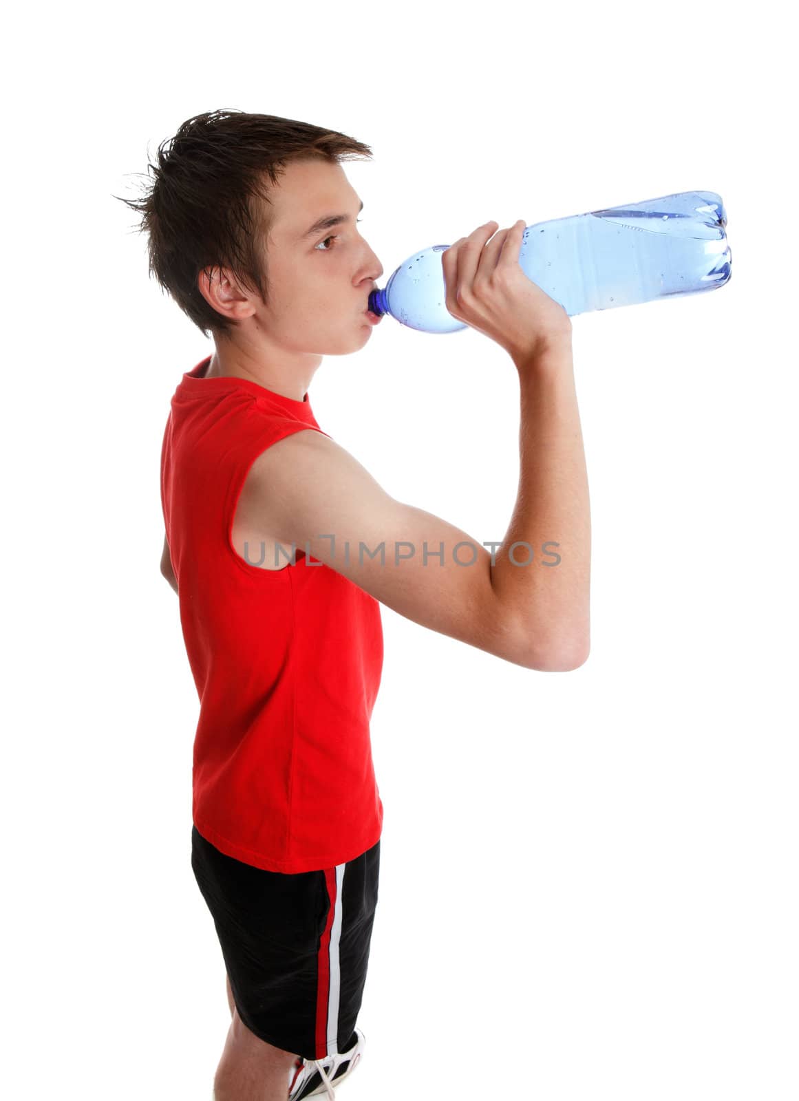 A young teenager drinking bottled water.   White background