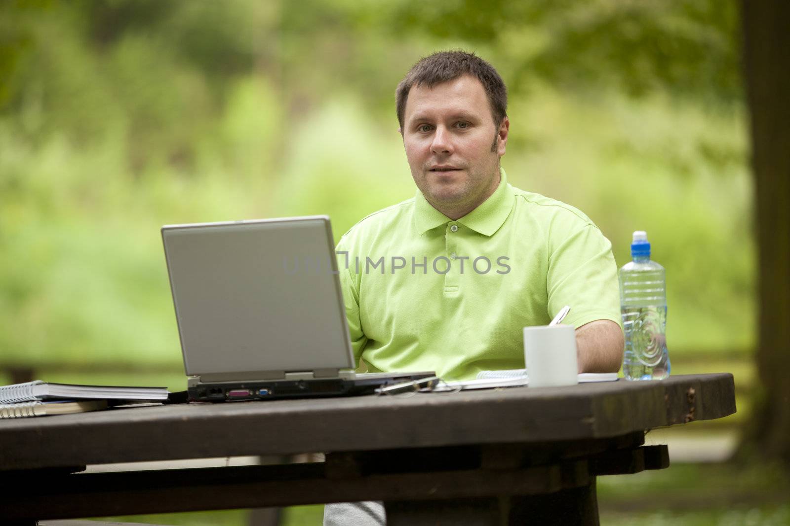 Man in green shirt at open space office in nature