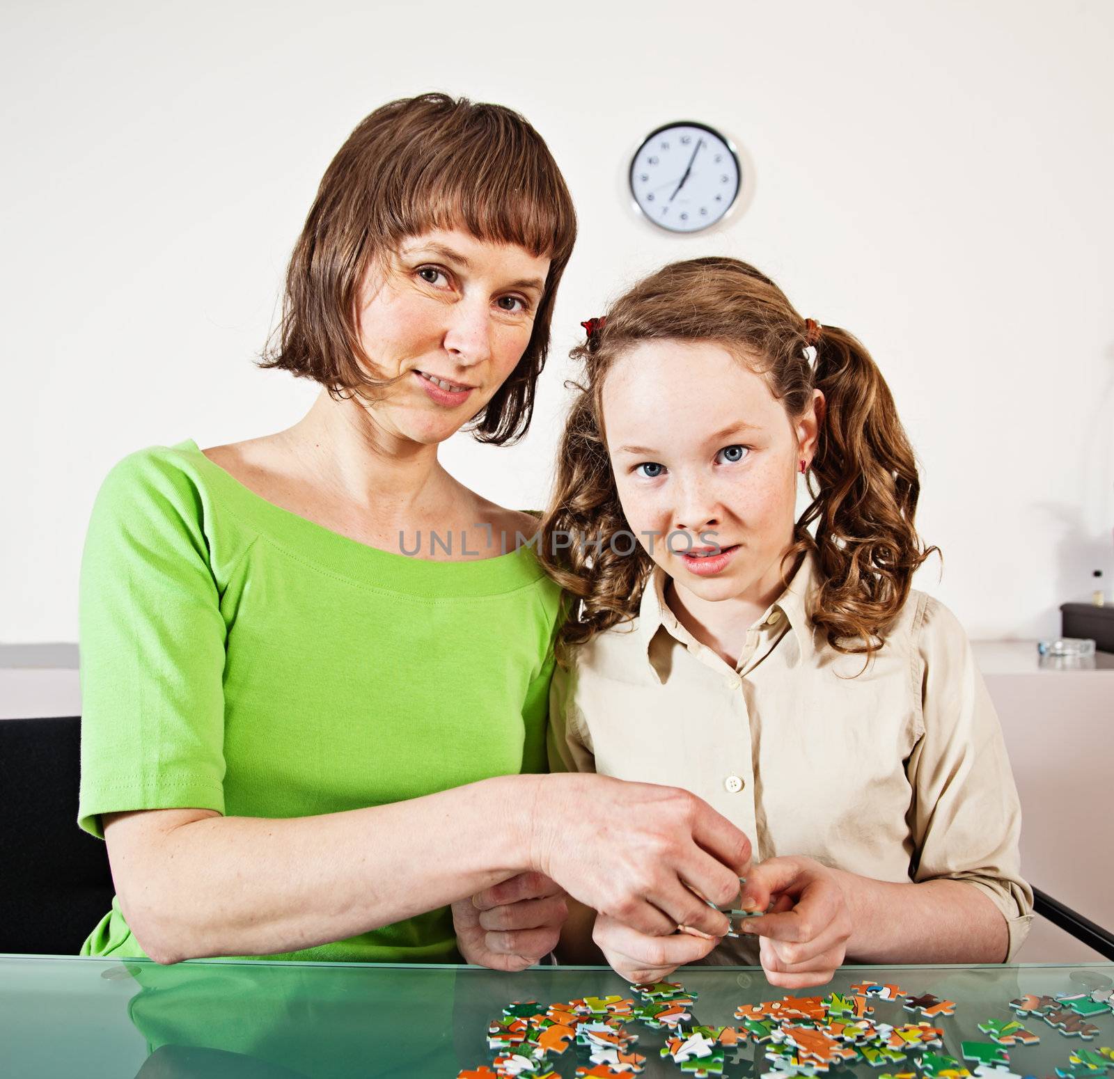 Teenager girl and her mother doing a puzzle at home