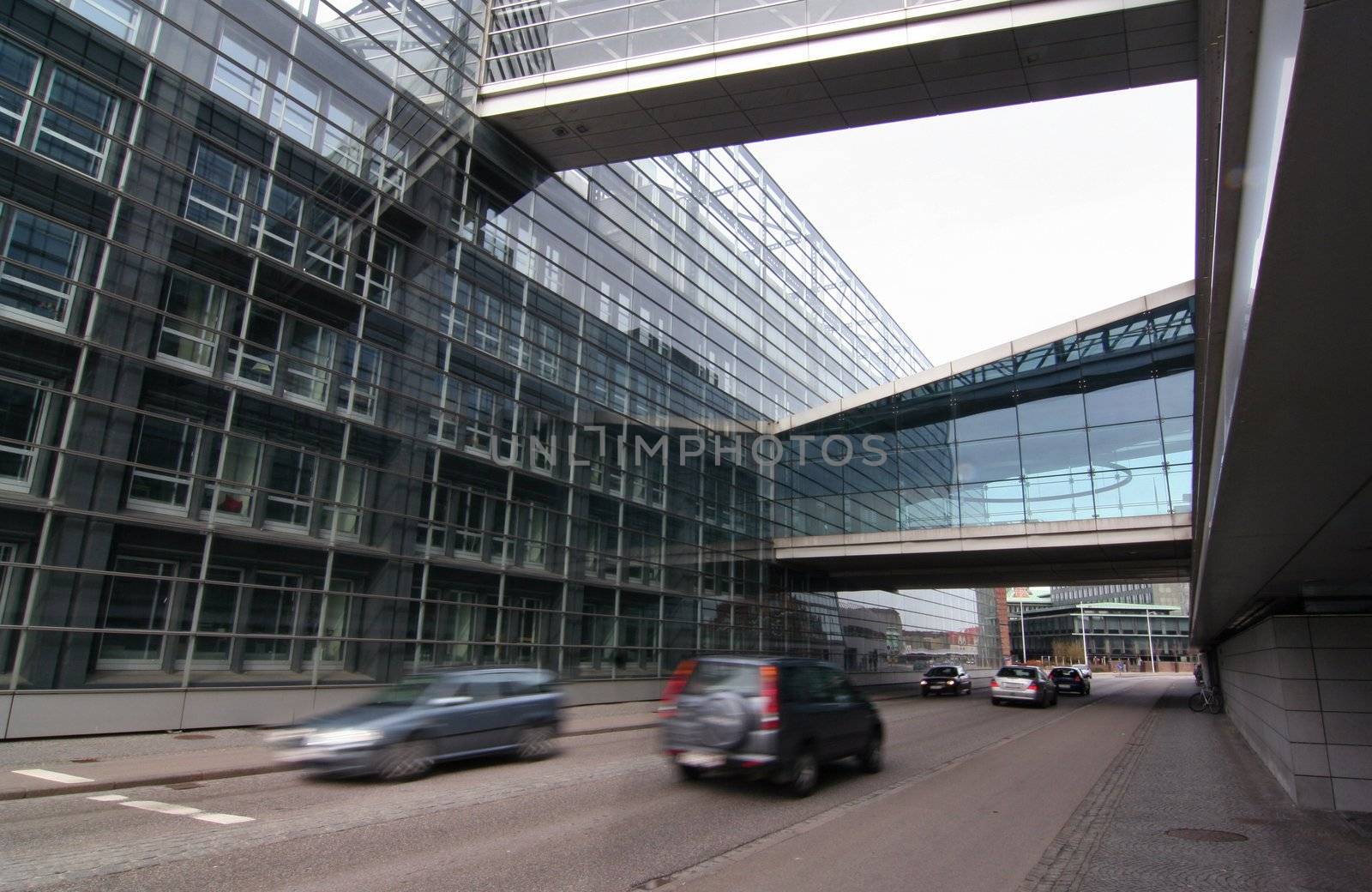 A modern office building beside road with cars passing in motion blur.