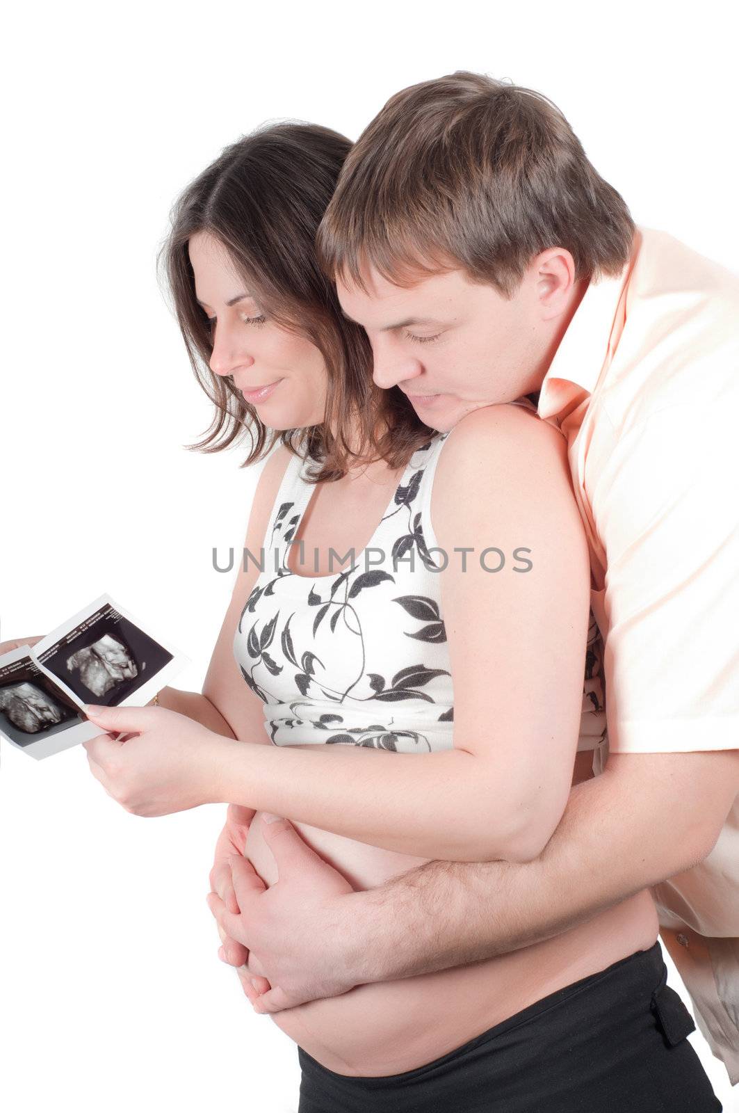 Happy young couple holding a sonogram of their child