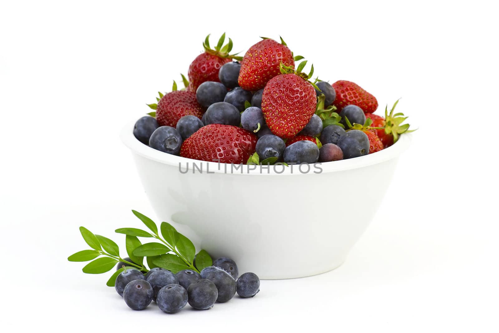 Strawberries and blueberries in a white bowl