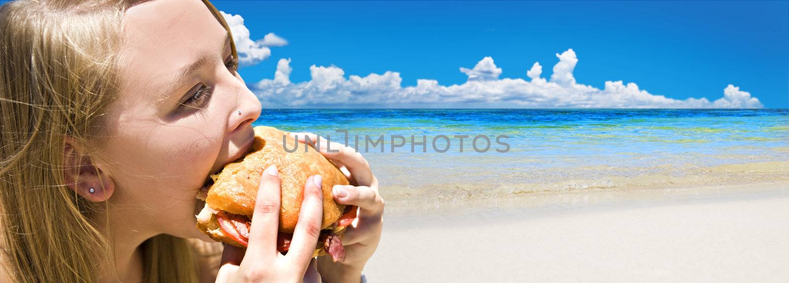 Tropical beach with young woman eating a bacon burger