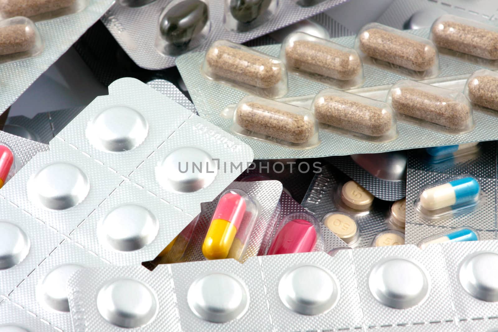 Pills of many shapes and colors grouped together