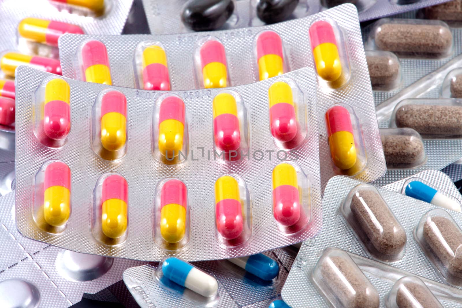 Pills of many shapes and colors grouped together