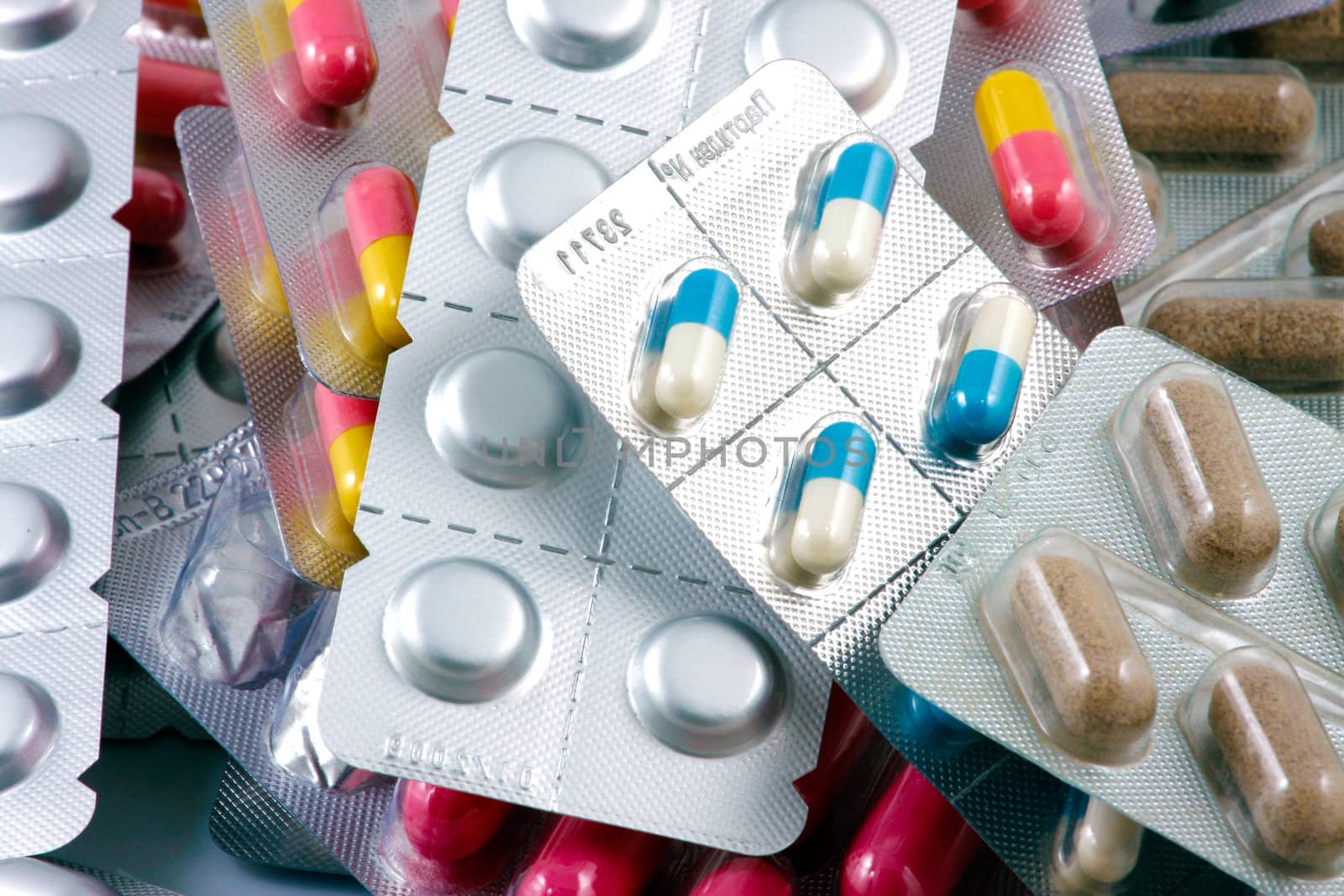 Pills of many shapes and colors grouped together