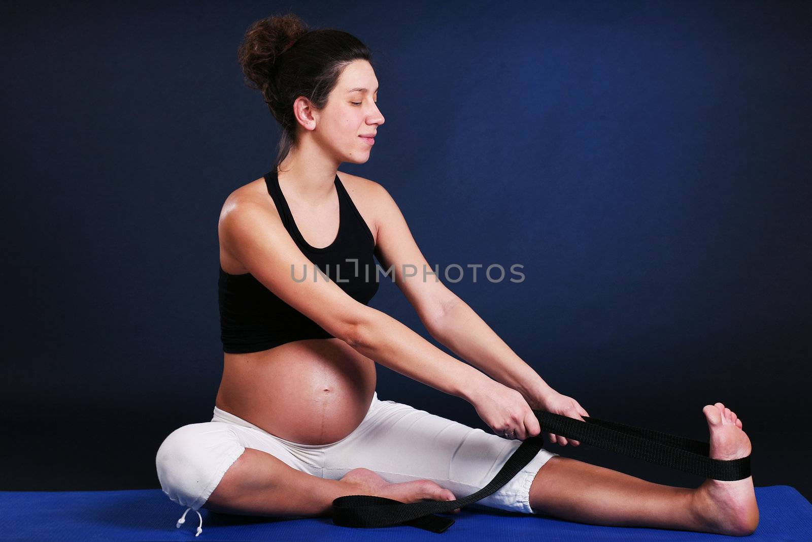 Beautiful pregnant  young woman practicing yoga on black