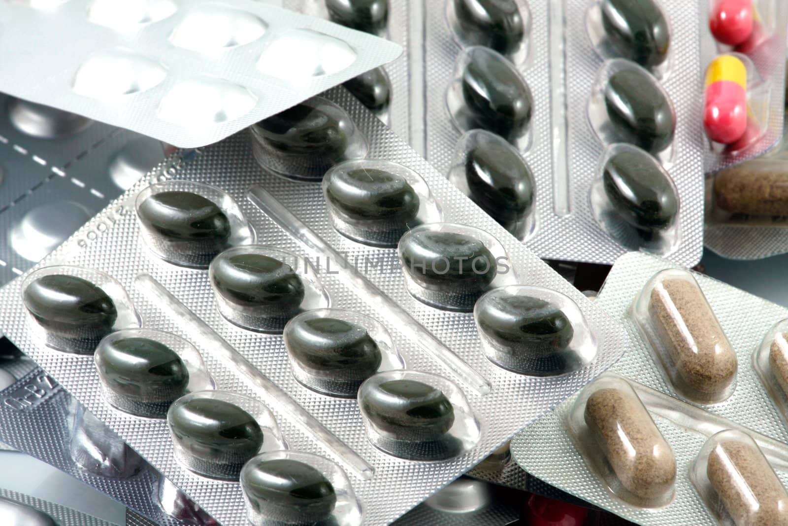 Pills of many shapes and colors grouped together