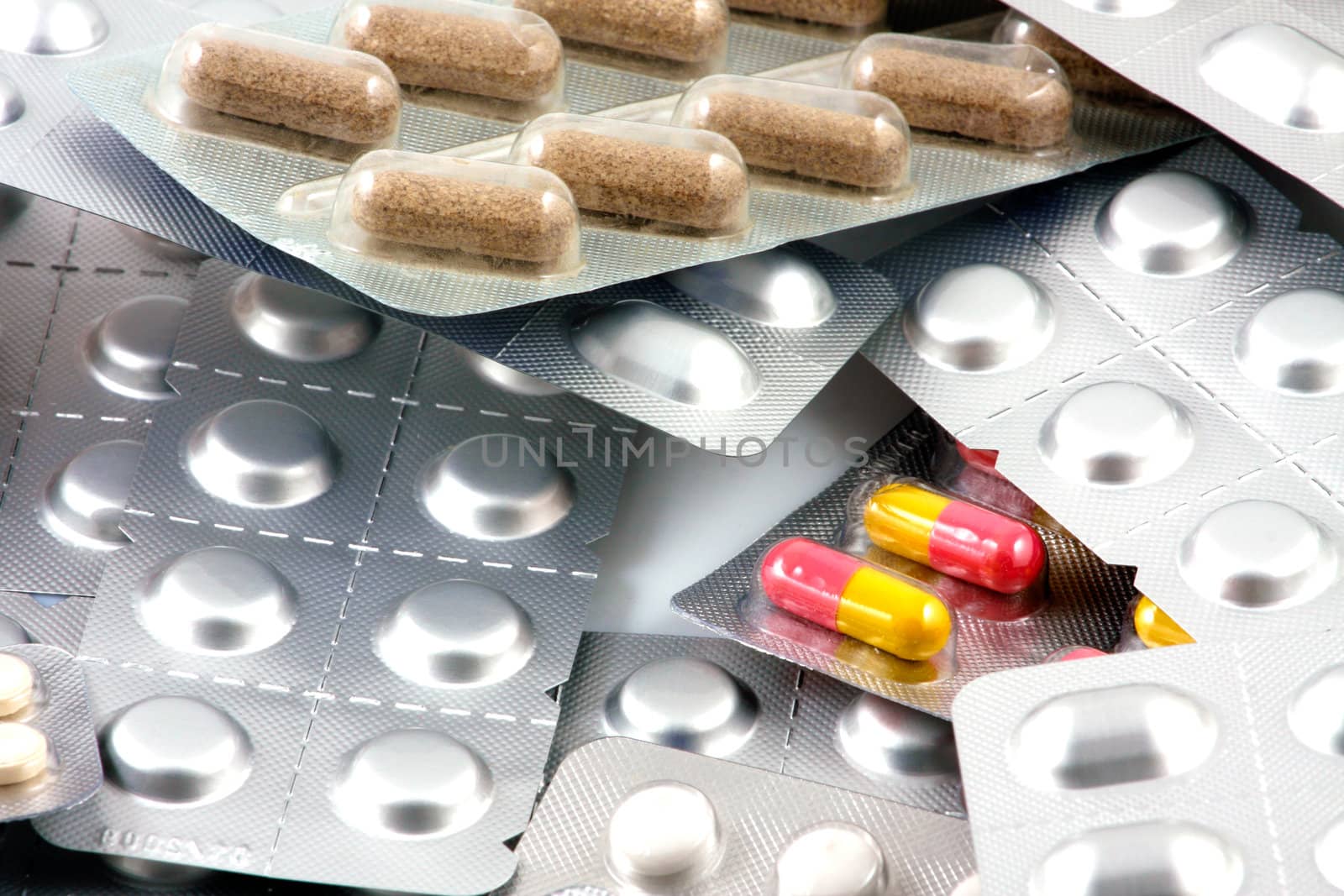 Pills of many shapes and colors grouped together