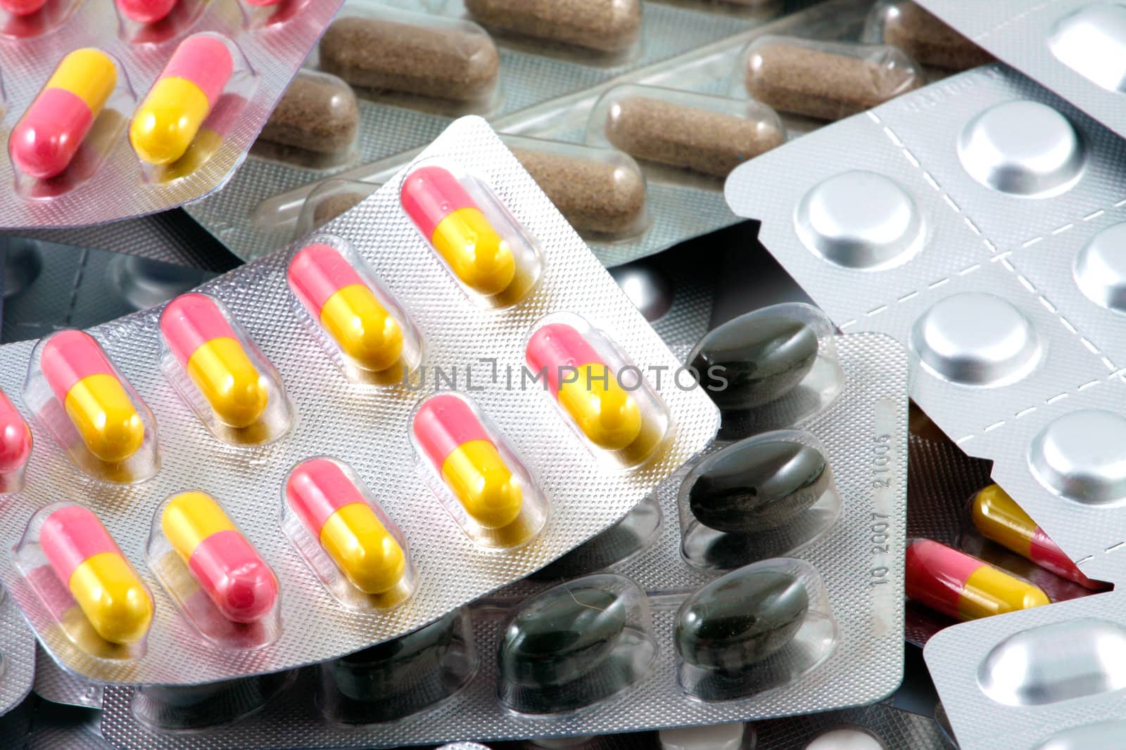 Pills of many shapes and colors grouped together
