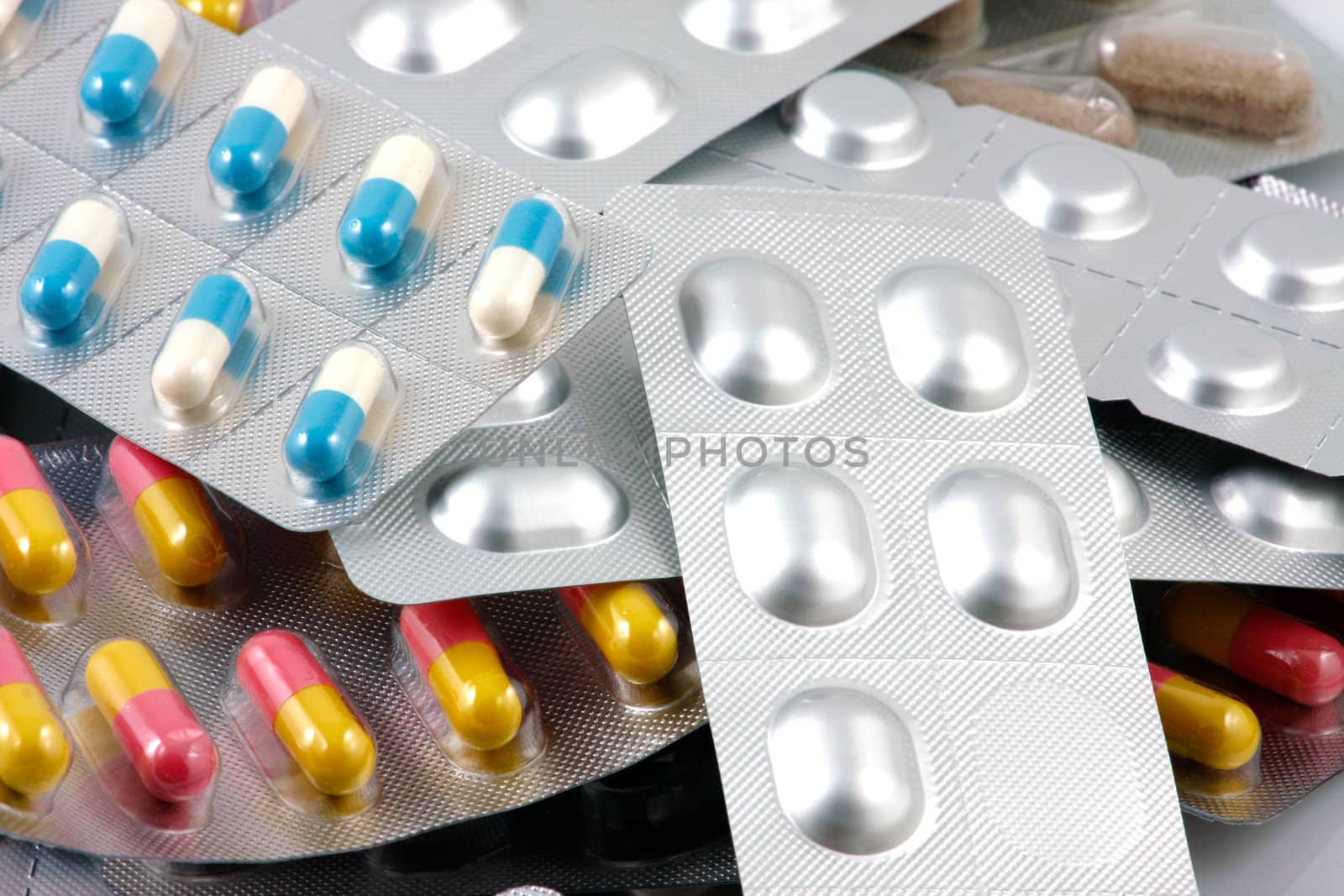 Pills of many shapes and colors grouped together