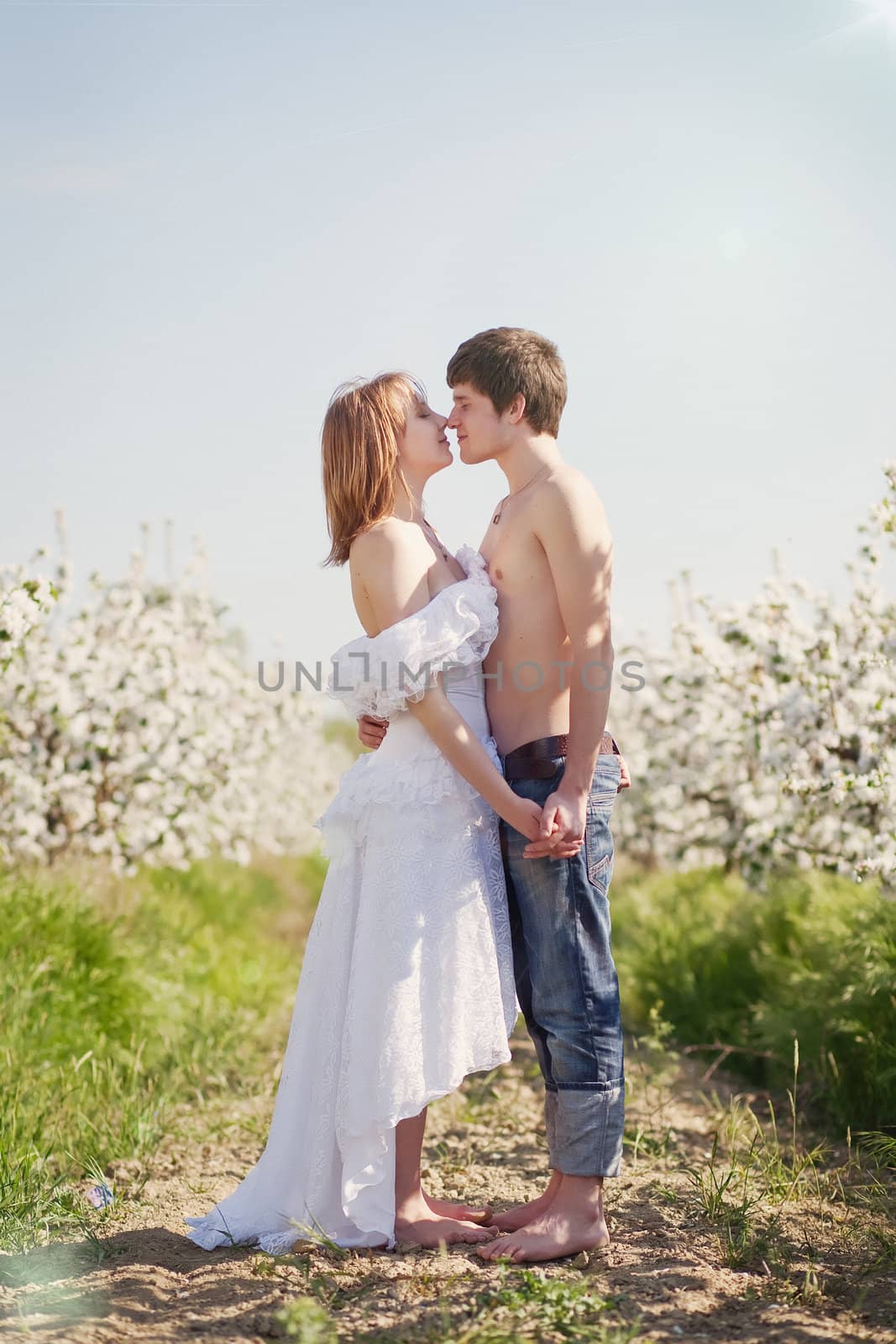 beautiful young couple kissing in the flowering gardens