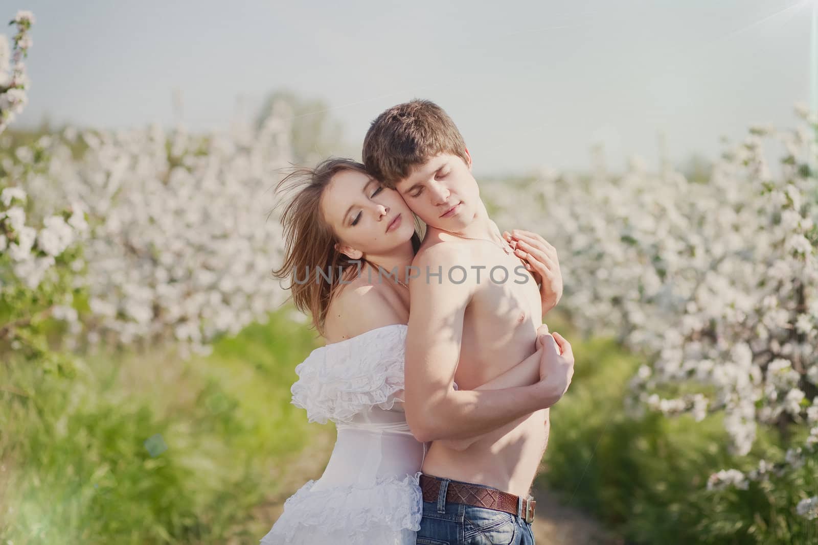 beautiful young couple kissing in the flowering gardens