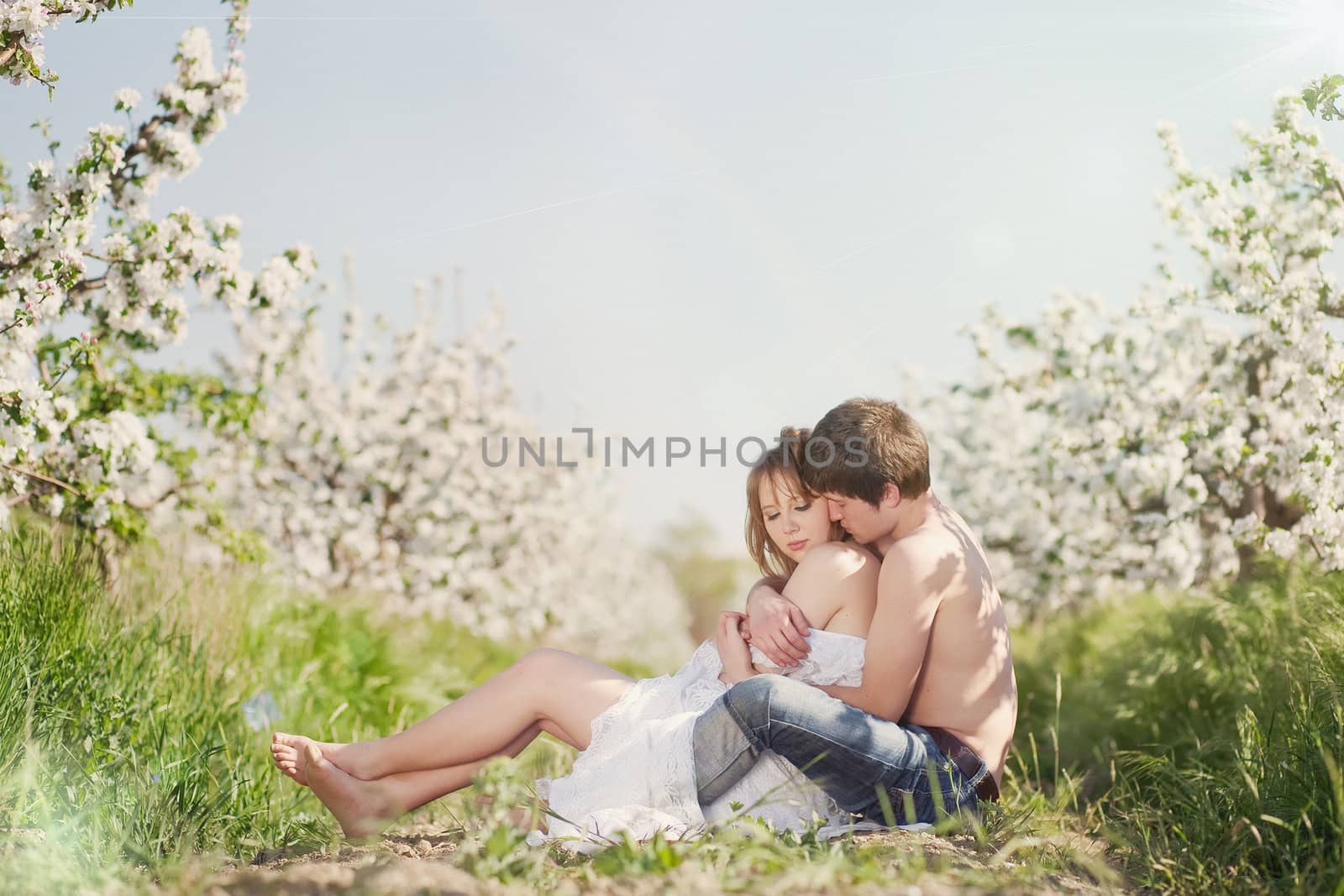 beautiful young couple kissing in the flowering gardens