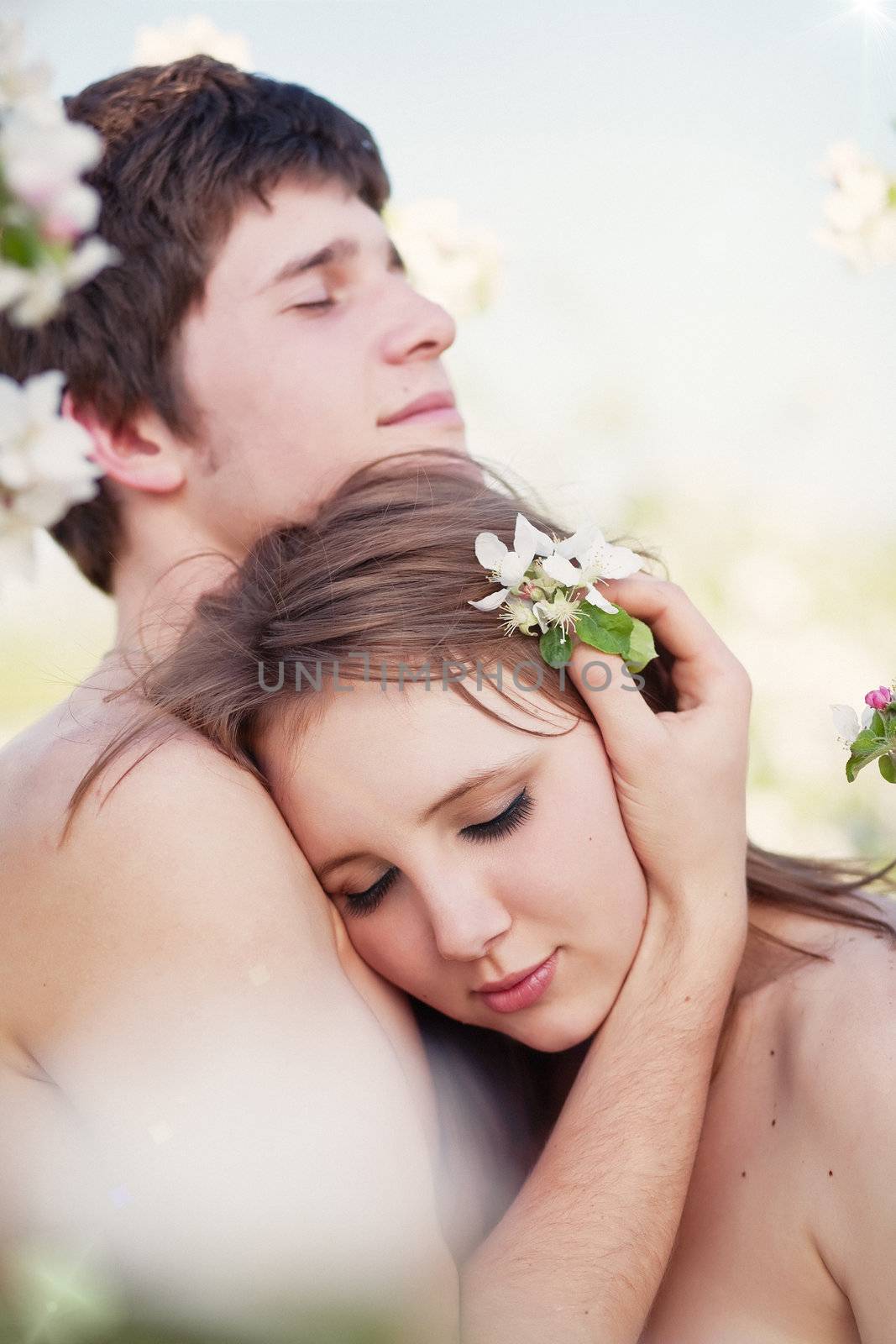 beautiful young couple kissing in the flowering gardens