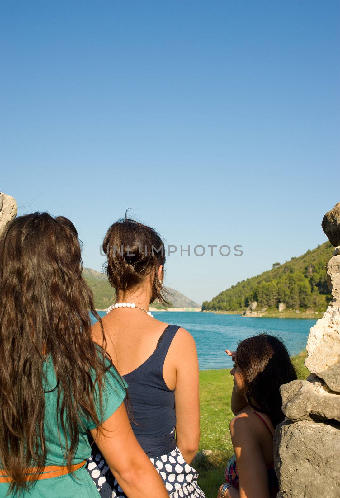 Three friends enjoying an outlook on a lake