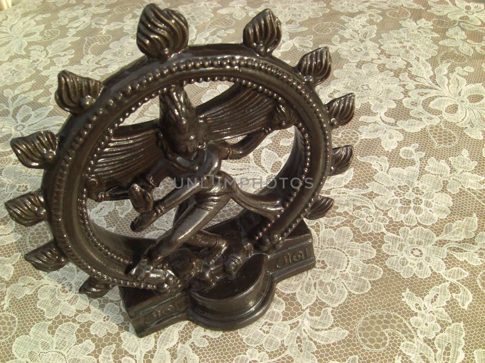 Small statue of Shiva on an indian table. Shiva is also called the Lord of Dance. The rhythm of dance is a metaphor for the balance in the universe which Shiva is believed to hold