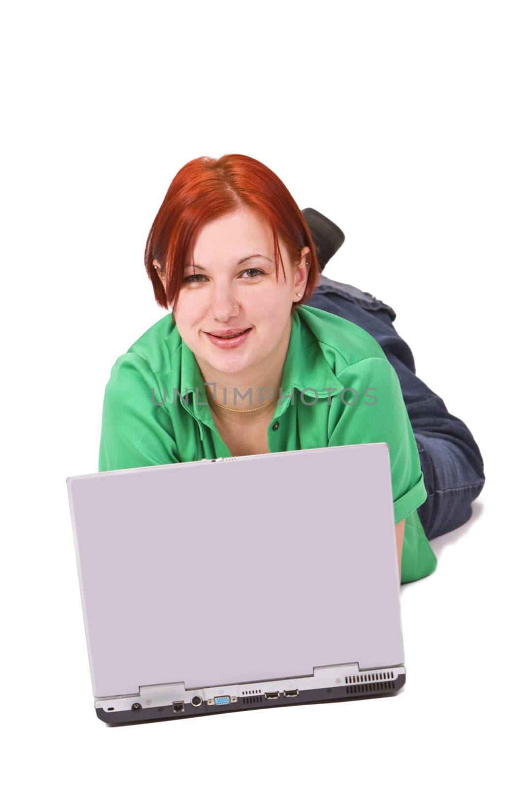Portrait of a smilling redheaded teenage girl lying down in front of a laptop.Shot with Canon 70-200mm f/2.8L IS USM