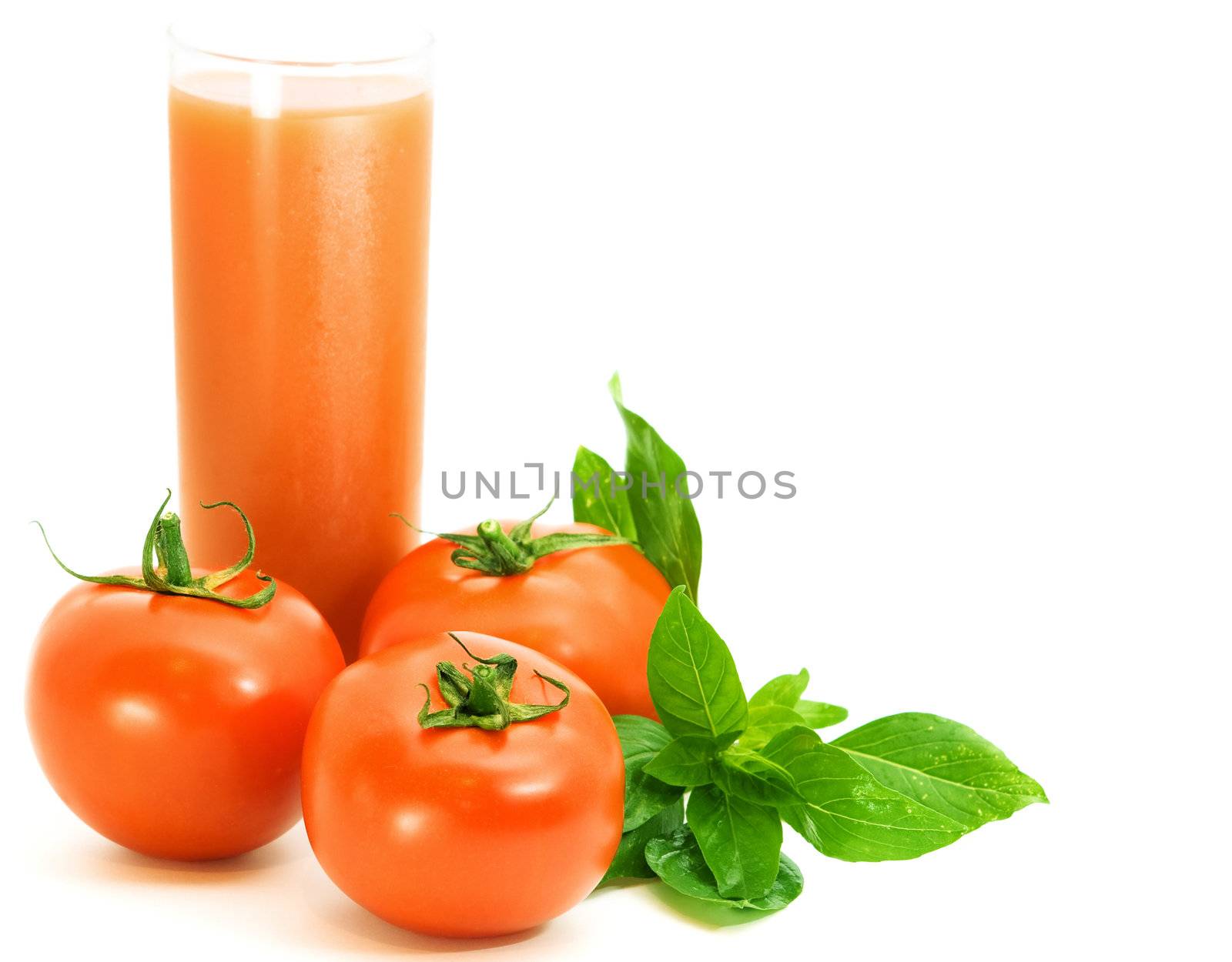 fresh tomatoes with basilico herb and glass of tomato juice over white