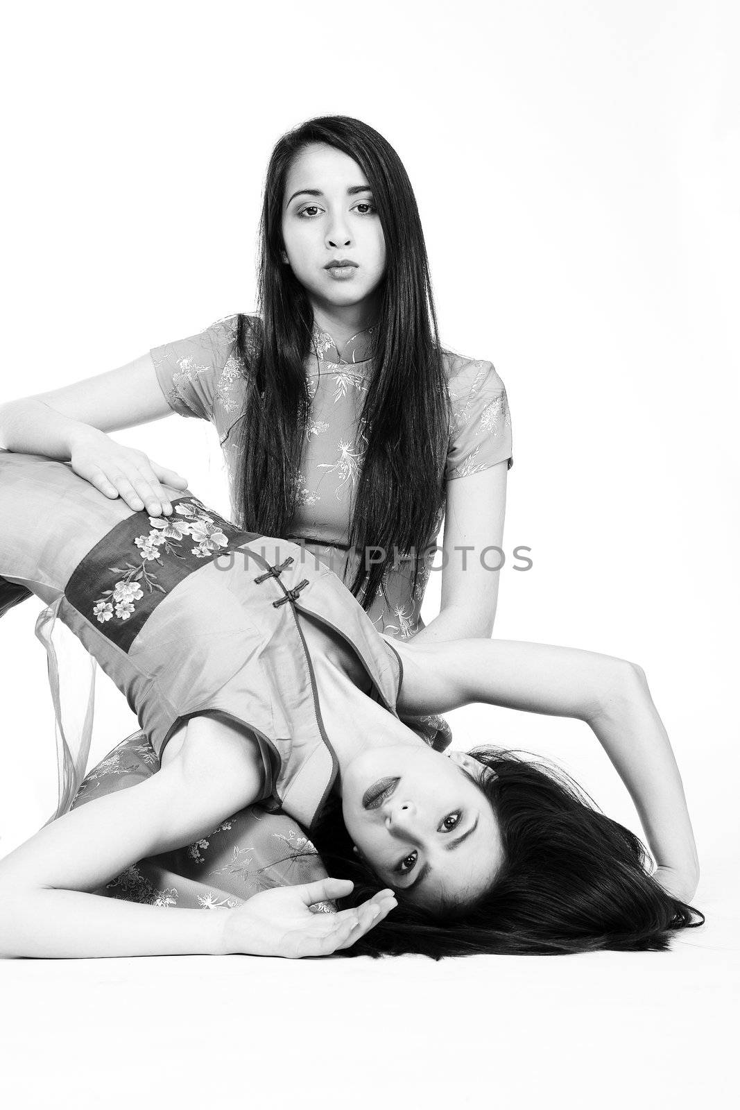 Studio portrait of two beautiful mixed race vietnamese sisters in black and white