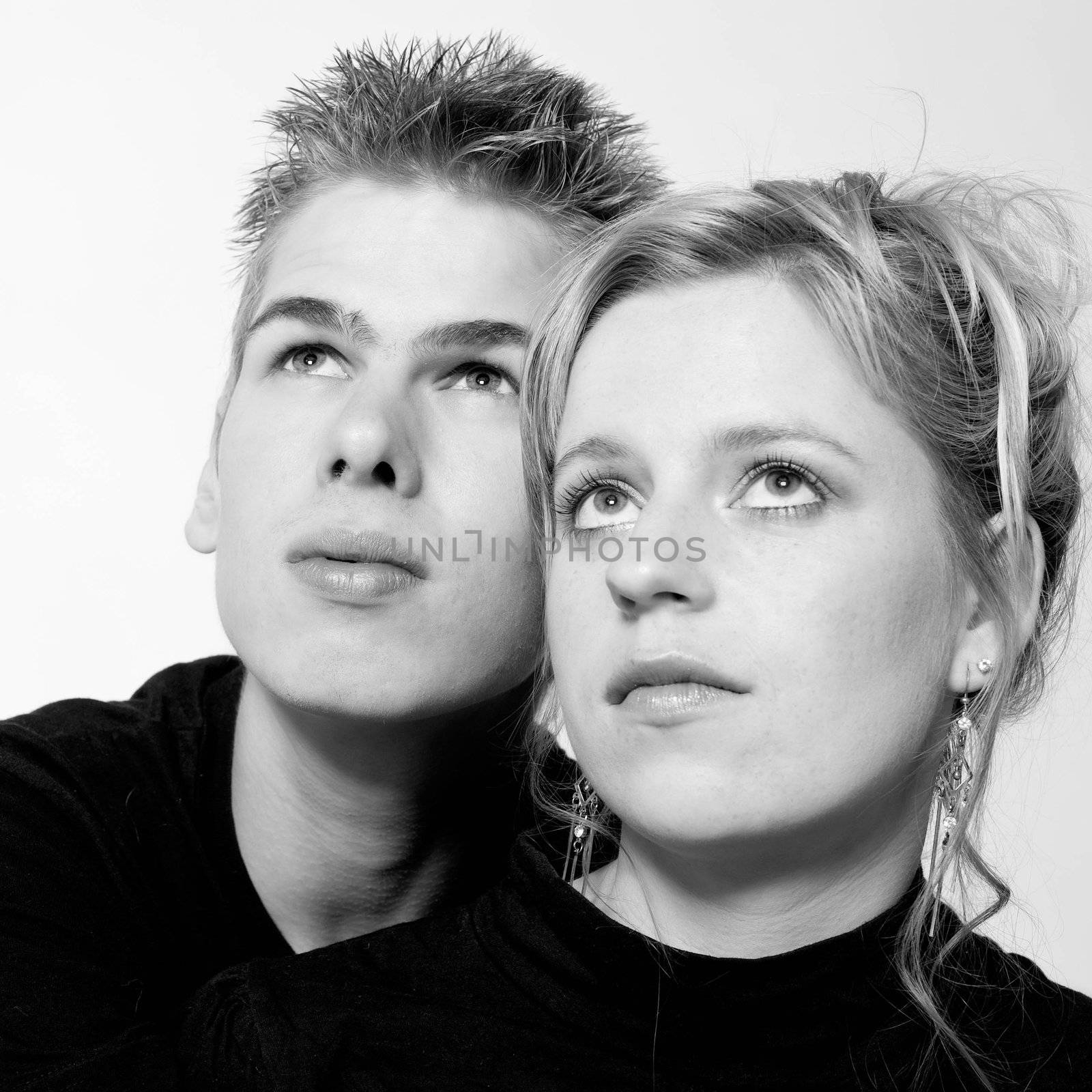 Couple of teenagers in the studio on a white background looking up

