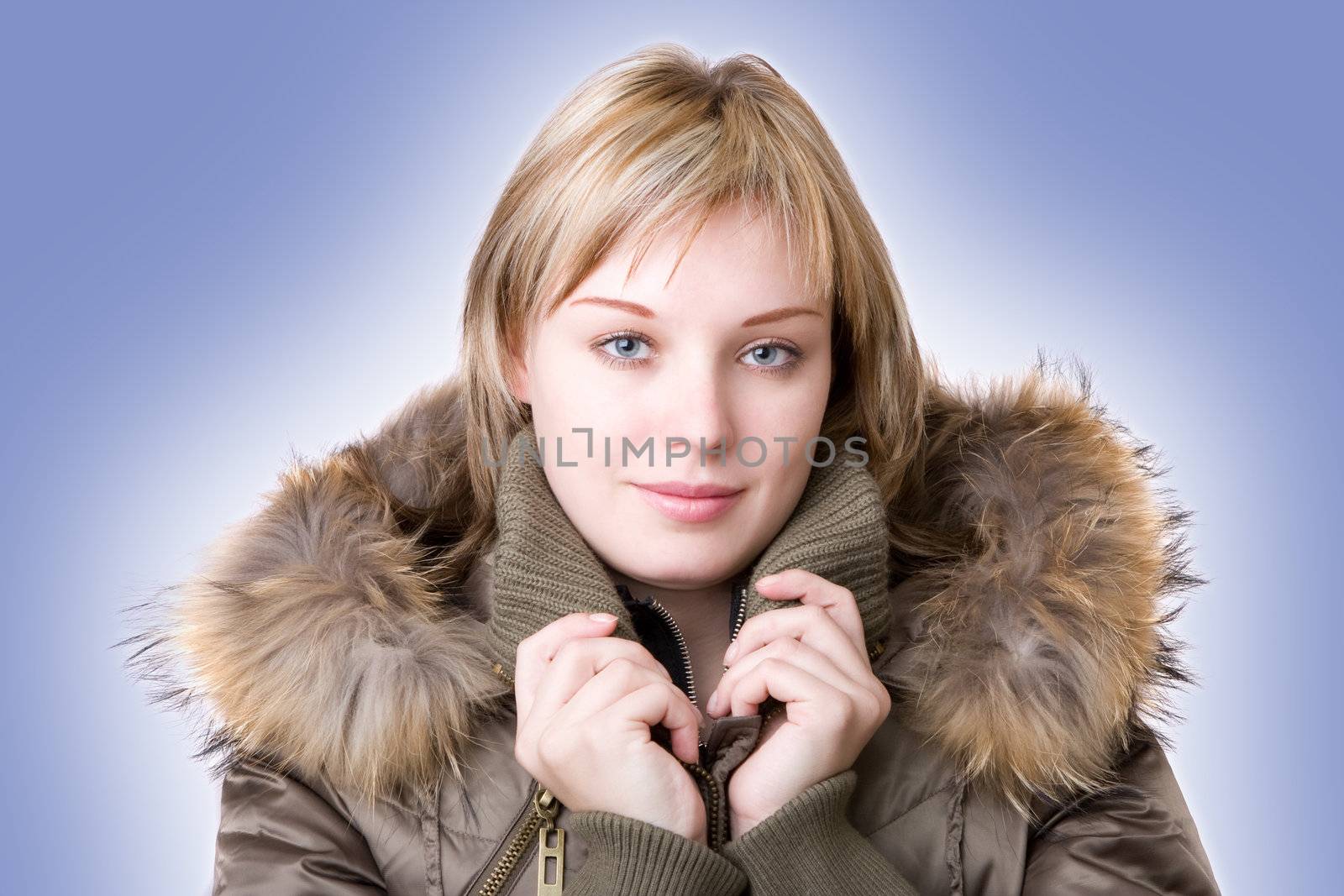 young girl in a jacket with a fur collar on a light blue background