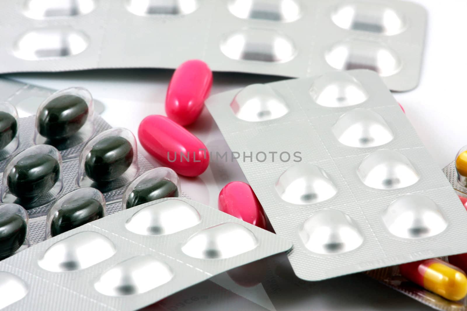 Pills of many shapes and colors grouped together