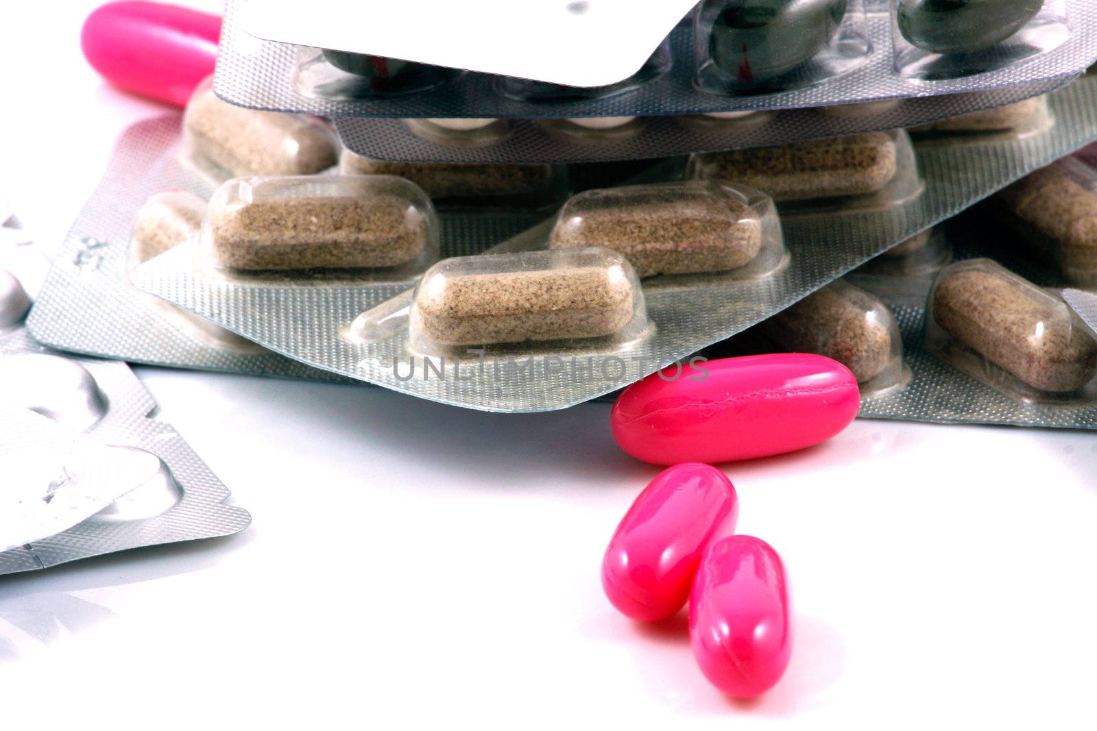 Pills of many shapes and colors grouped together